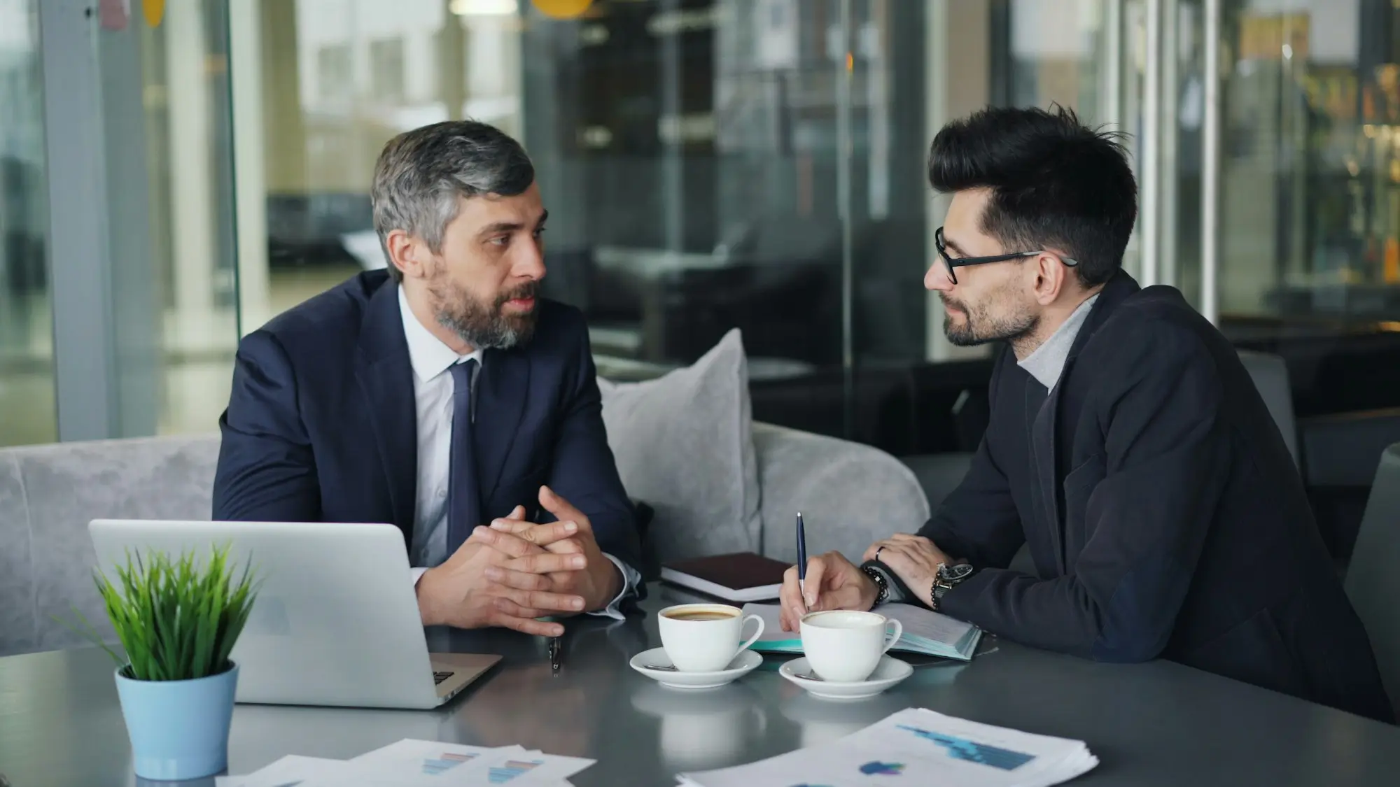 Two men talking through a plan at a table