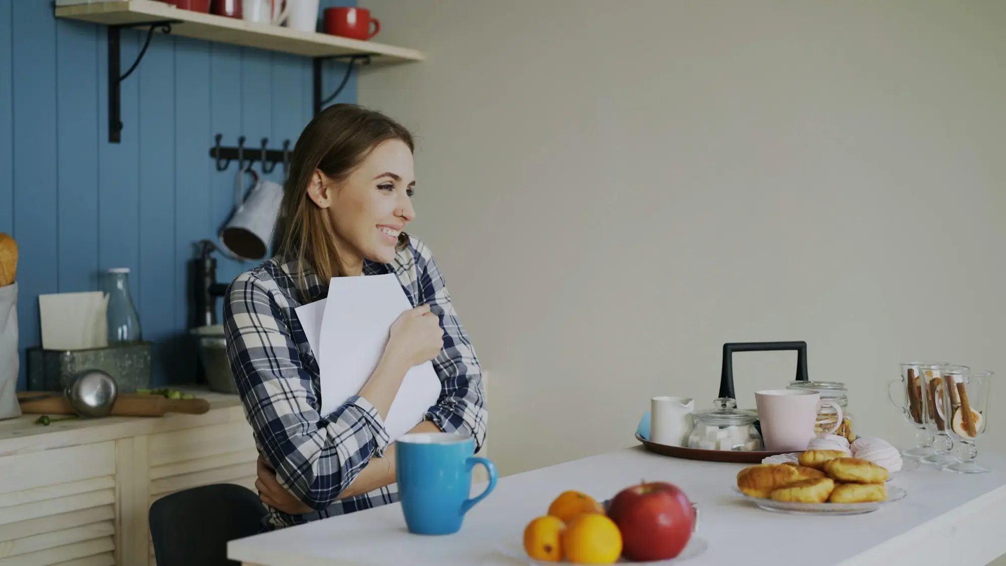 Woman reading paperwork at the kitchen table